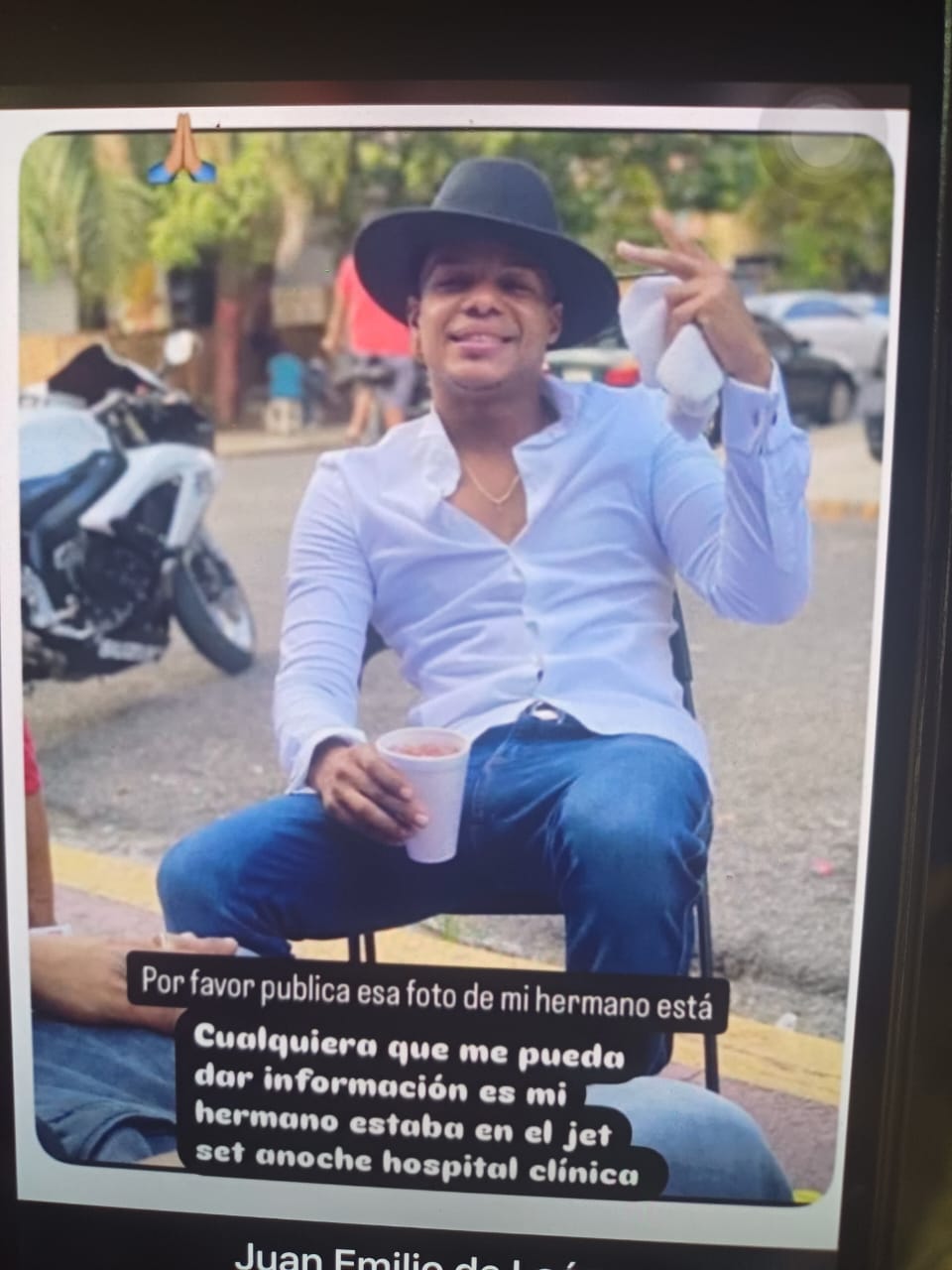 Hombre sonriente con sombrero negro y bebida