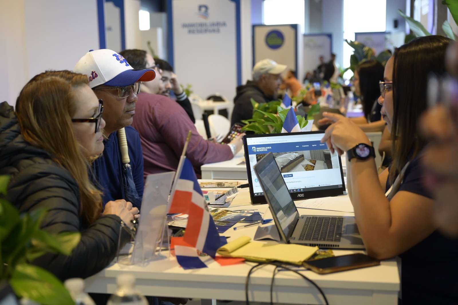 Personas en reunión con portátiles y banderas dominicanas.