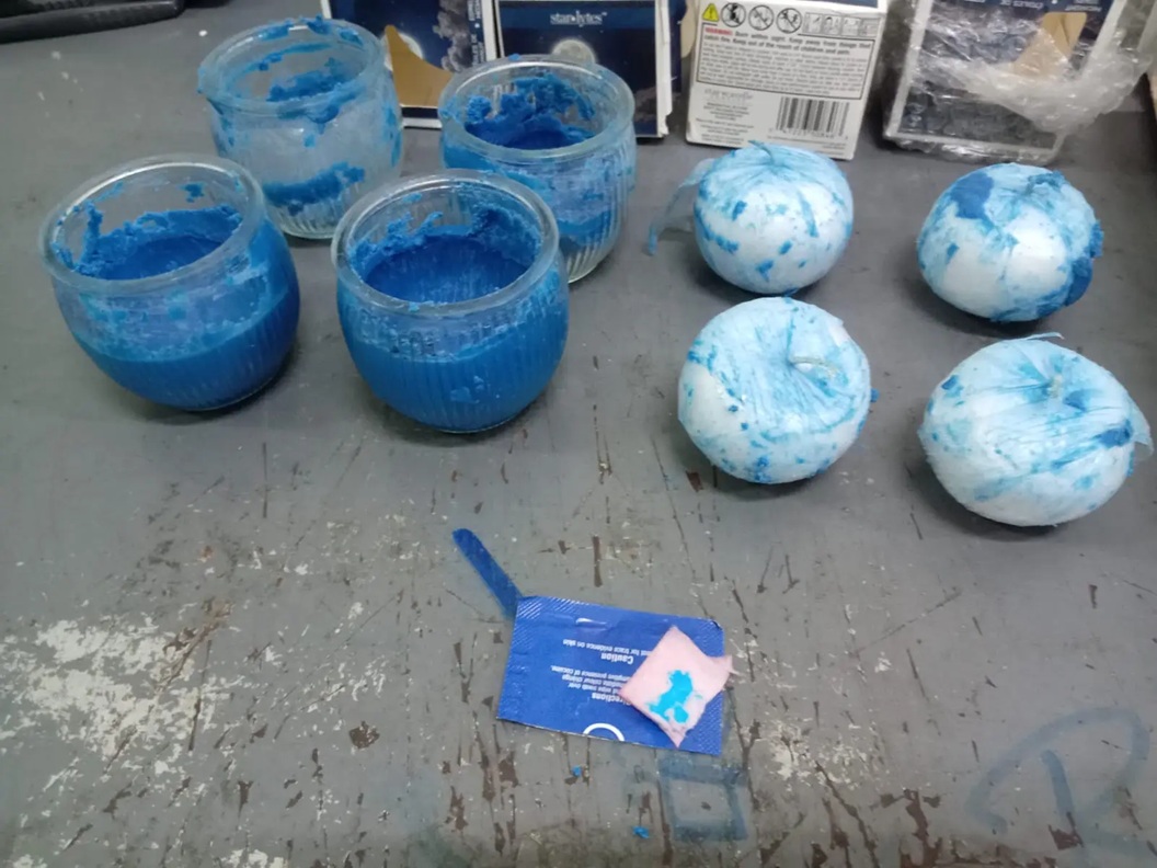 Frascos y pelotas con pasta azul sobre mesa