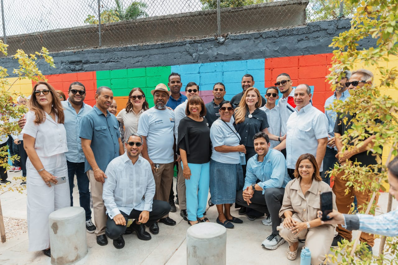 Grupo de personas frente a mural colorido.