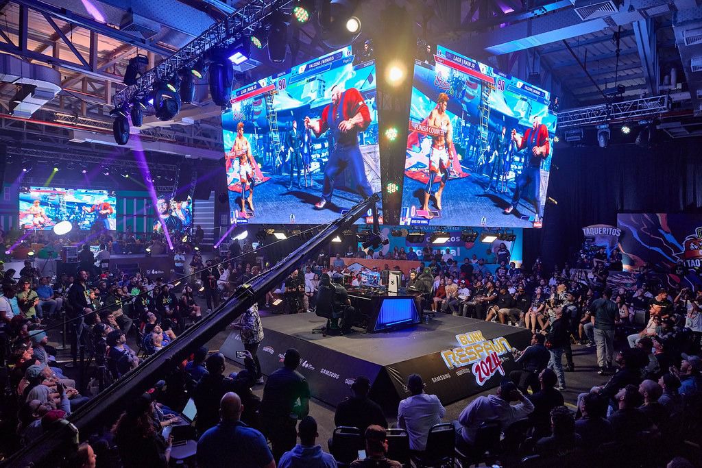 Competencia de videojuegos en evento esport, público y pantallas.