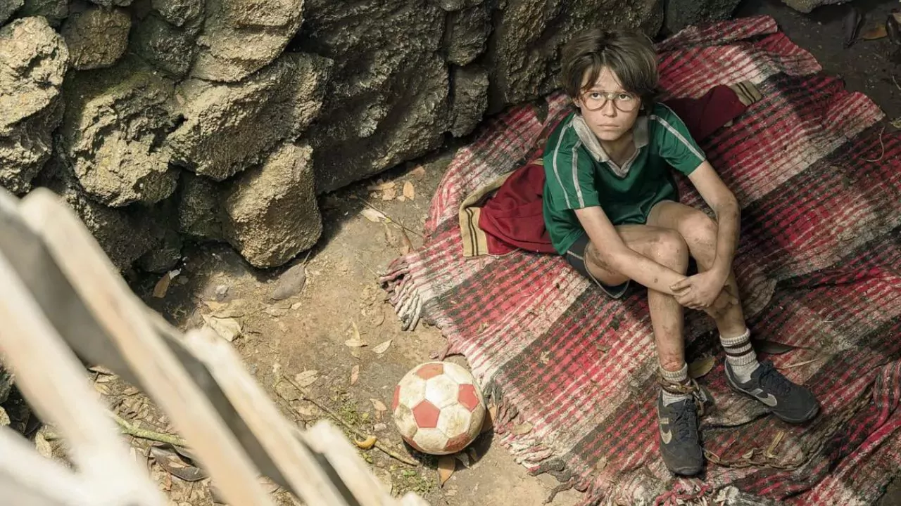 Niño con gafas sentado junto a un balón en una escena de No tengo miedo, serie de Netflix ambientada en Veracruz